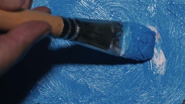Artist copyist paint seascape with ship in ocean. Craftsman decorator draw as boat sail on blue sea with acrylic oil color. Draw finger, brush, knife palette. Indoor. Close up cinematic look.