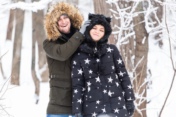 Young couple have fun in a snowy park. Winter season.