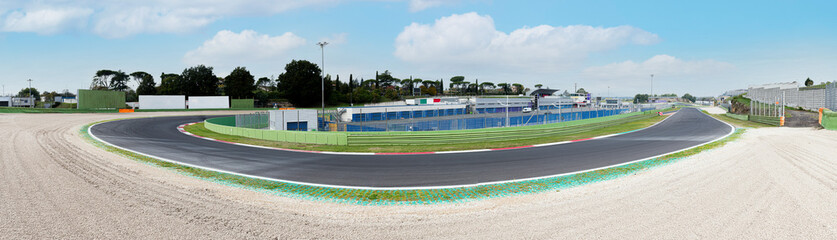 Asphalt motor sport circuit turn wide panoramic view of track and external gravel trap