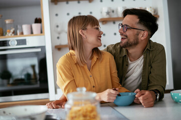 Young couple eating breakfast at home. Loving couple enjoying in the kitchen...