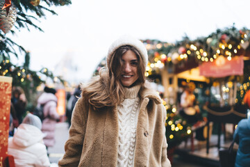 Happy young woman enjoying Christmas time in crowded street