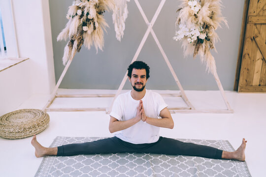 Positive Ethnic Man Doing Splits On Carpet