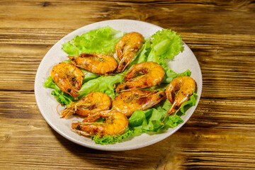 Tasty baked shrimps on a wooden table