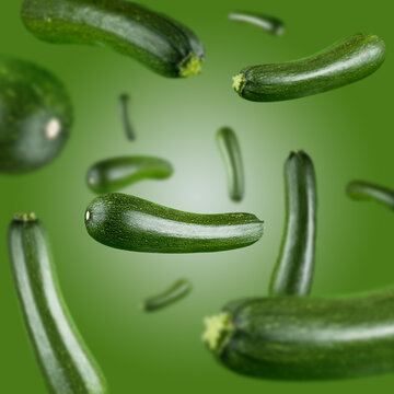 Many zucchini free falling on green background. Selective focus - shallow depth of field