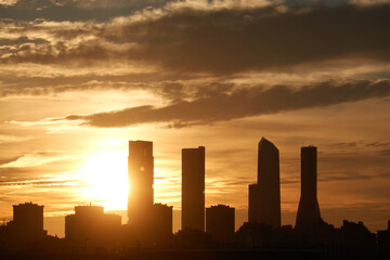 The sunset behind the Cuatro Torres de Madrid seen from the Valdebebas forest park. Spain