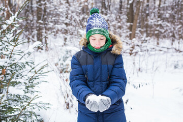 Fototapeta na wymiar Happy boy throwing snow. Child, season and winter concept.