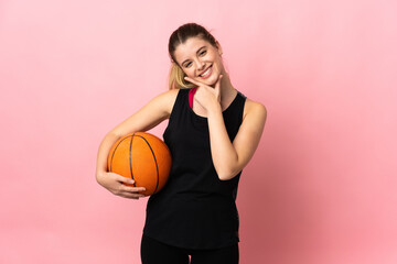 Young blonde woman playing basketball isolated on pink background happy and smiling