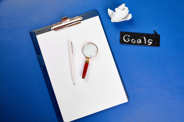 Flat lay of concept of search idea, goals, Business image, Magnifying glass and crumpled paper