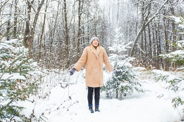 Young woman throwing snow in the air at sunny winter day, she is happy and fun.