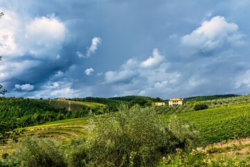 Fototapeta na wymiar Picturesque Farm Field in Rural Tuscany with Clouds