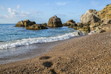 footprints on the sea beach with large stones