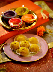 Festive Diwali set up background with gift box, sweets and traditional earthen lamps. Hindu religious festive objects.