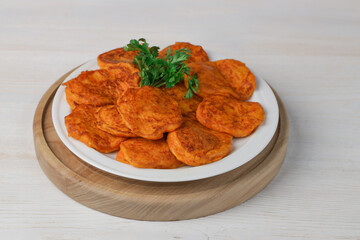 Pumpkin cutlets. Vegetable burgers on a white plate on a light wooden background. Close-up. Vegetarian food.