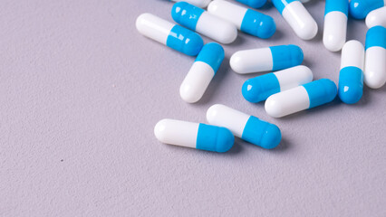 white and blue pills on a gray background. medical background