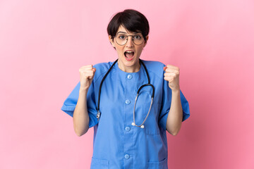 Surgeon isolated on pink background celebrating a victory in winner position