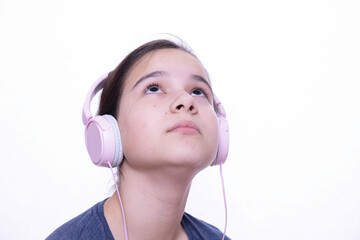 teenage girl in headphones listening to music dreaming looking up