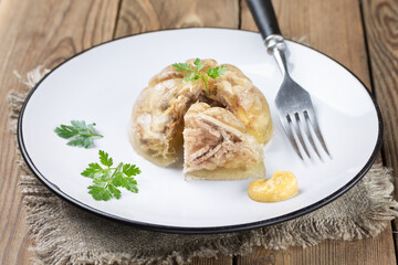 A portion of jelly with a cut slice, with mustard. Rustic