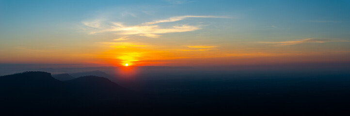 Panorama colorful sunset on top of asian mountain.The sun rising from the mountain peaks.