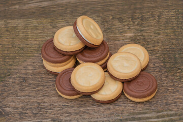 Three flavors in a single biscuit, two sides and a delicious cream in the middle. On wooden background