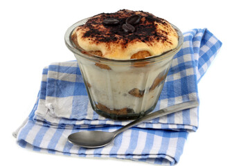 Tiramisu maison servi dans un ramequin posé sur une serviette de table sur fond blanc