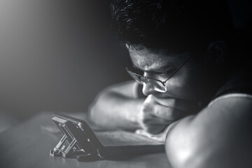 Close portrait shot of a male teenager watching something interesting on his phone.