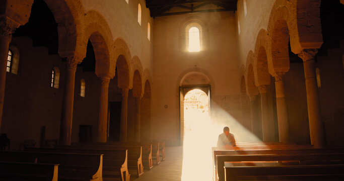 Vichingo o normanno con cotta di maglia in testa mentre prega in chiesa in ginocchio.