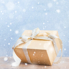 christmas gifts box with ribbon on glitter blue and wooden background with snow. new year card 2021.