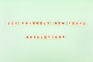 Phrase "Eco friendly new year's resolutions" in wooden letters on green background
