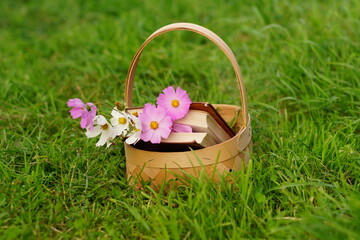 basket with a poem book and pink flowers