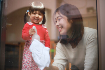 窓拭きする親子