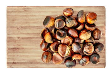 Horse chestnuts on a wooden cutting board. Roasted Chestnuts isolated on white background. Top view. Flat lay.