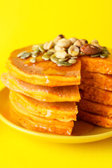 Plate with tasty pumpkin pancakes on color background, closeup