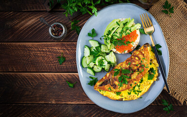 Omelette with forest mushroom, fusilli pasta and sandwich wich red caviar, avocado on plate.  Frittata - italian omelet. Top view, overhead, copy space