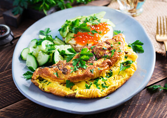 Omelette with forest mushroom, fusilli pasta and sandwich wich red caviar, avocado on plate.  Frittata - italian omelet.
