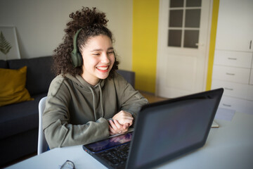 happy mixed rase girl sits at computer screen laptop. student talks over Internet. Video Conference...
