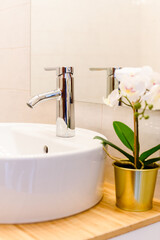 Fototapeta na wymiar Ceramic Water tap sink with faucet withdecorative flower in expensive loft bathroom or kitchen