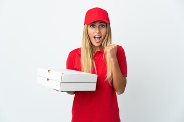 Pizza delivery woman holding a pizza isolated on white background celebrating a victory in winner position