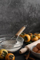 Food ingredients for cooking autumn sweet pie with raw persimmons