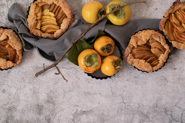 Ready to eat sweet pie with persimmons on grey cement background