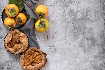 Ready to eat sweet pie with persimmons on grey cement background