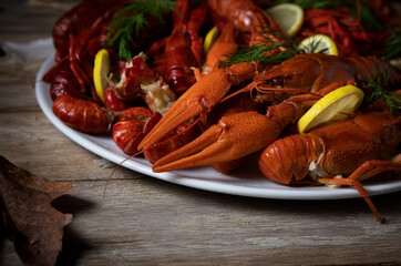 
White plate with boiled crayfish on a wooden table