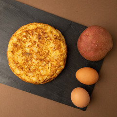 omelette with potatoes on brown background