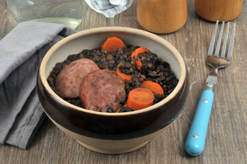 Bowl of lentils and sausage with fork close up