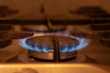 Burning blue flames gas. Focus on the front edge of the gas burners.