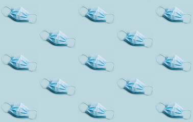 Obraz premium Bizarre medical mask wallpaper concept. Blue disposable virus prevention masks on red background. 