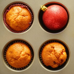 Freshly baked muffins on gray baking sheet for Christmas holidays. New Year holiday decorations.