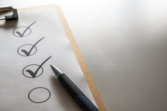 Abgehakte Checkliste auf einem grauen Schreibtisch mit Kugelschreiber