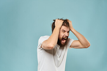 Man gestures with his hands emotions displeasure white t-shirt blue background
