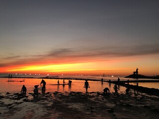 Fototapeta premium beautiful sunset at mudflat and happy people