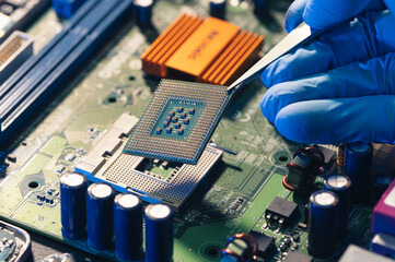 The technician is putting the CPU on the socket of the computer motherboard.